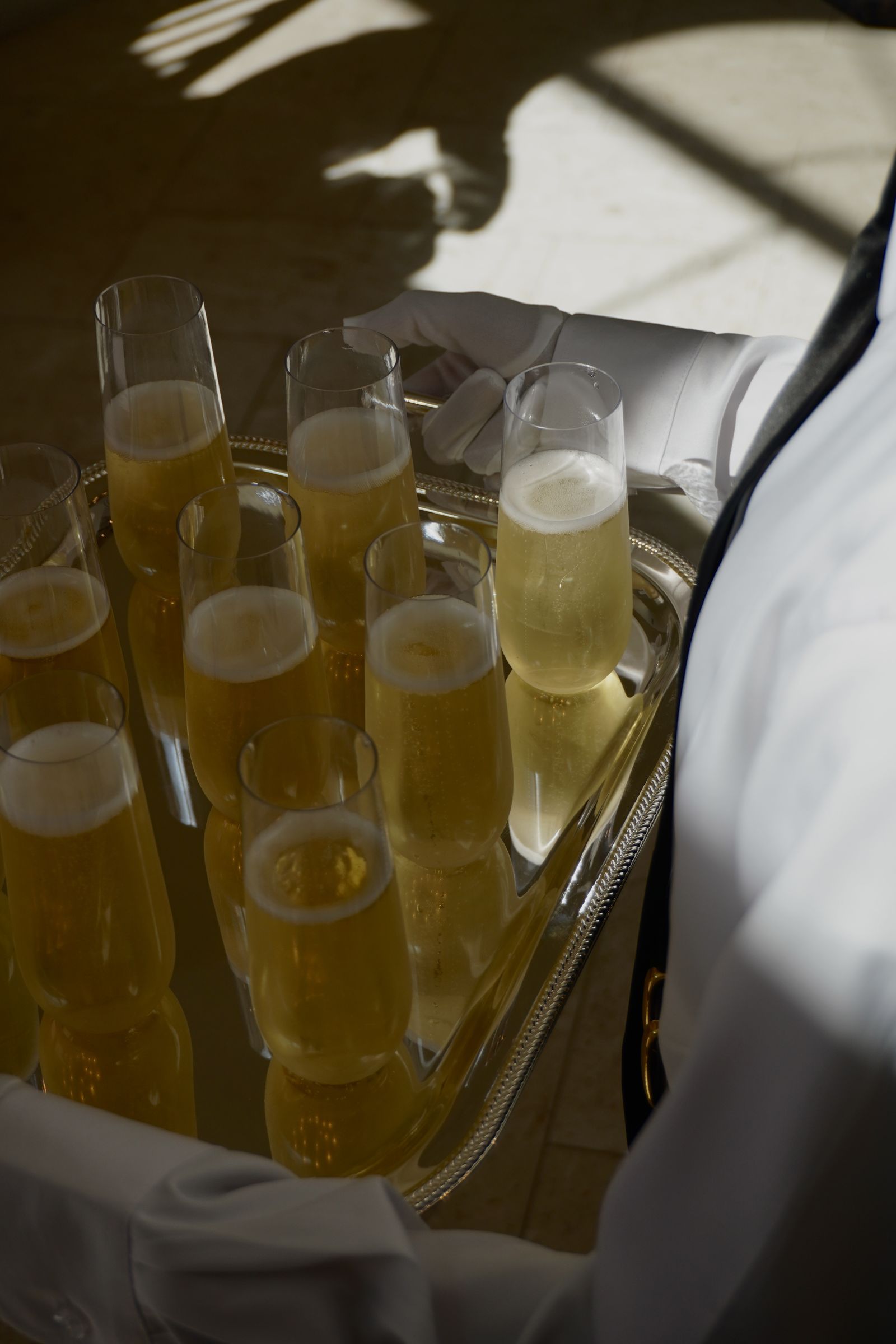 Overhead view of champagne flutes on a silver tray