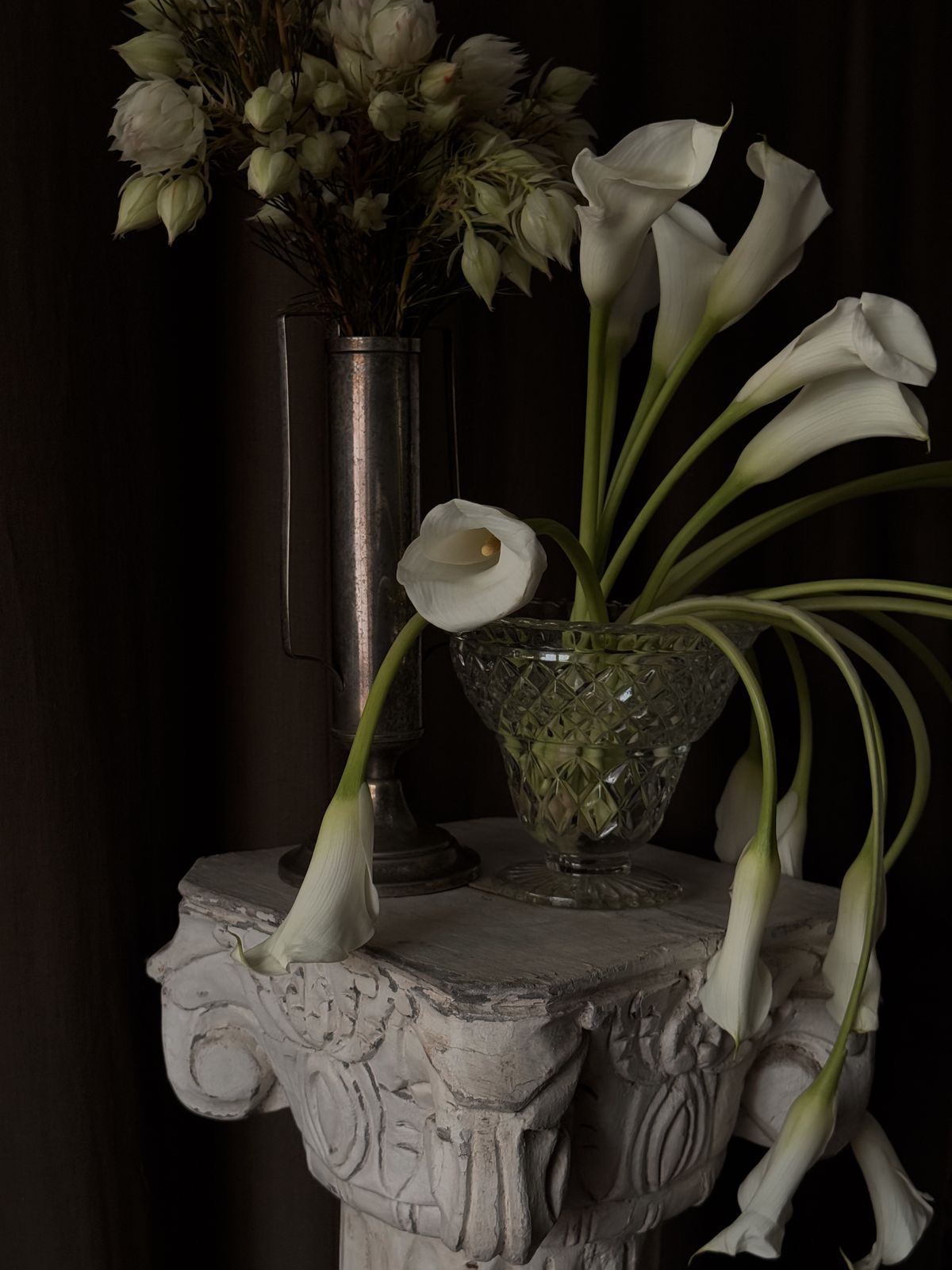 Calla lilies on carved stone column
