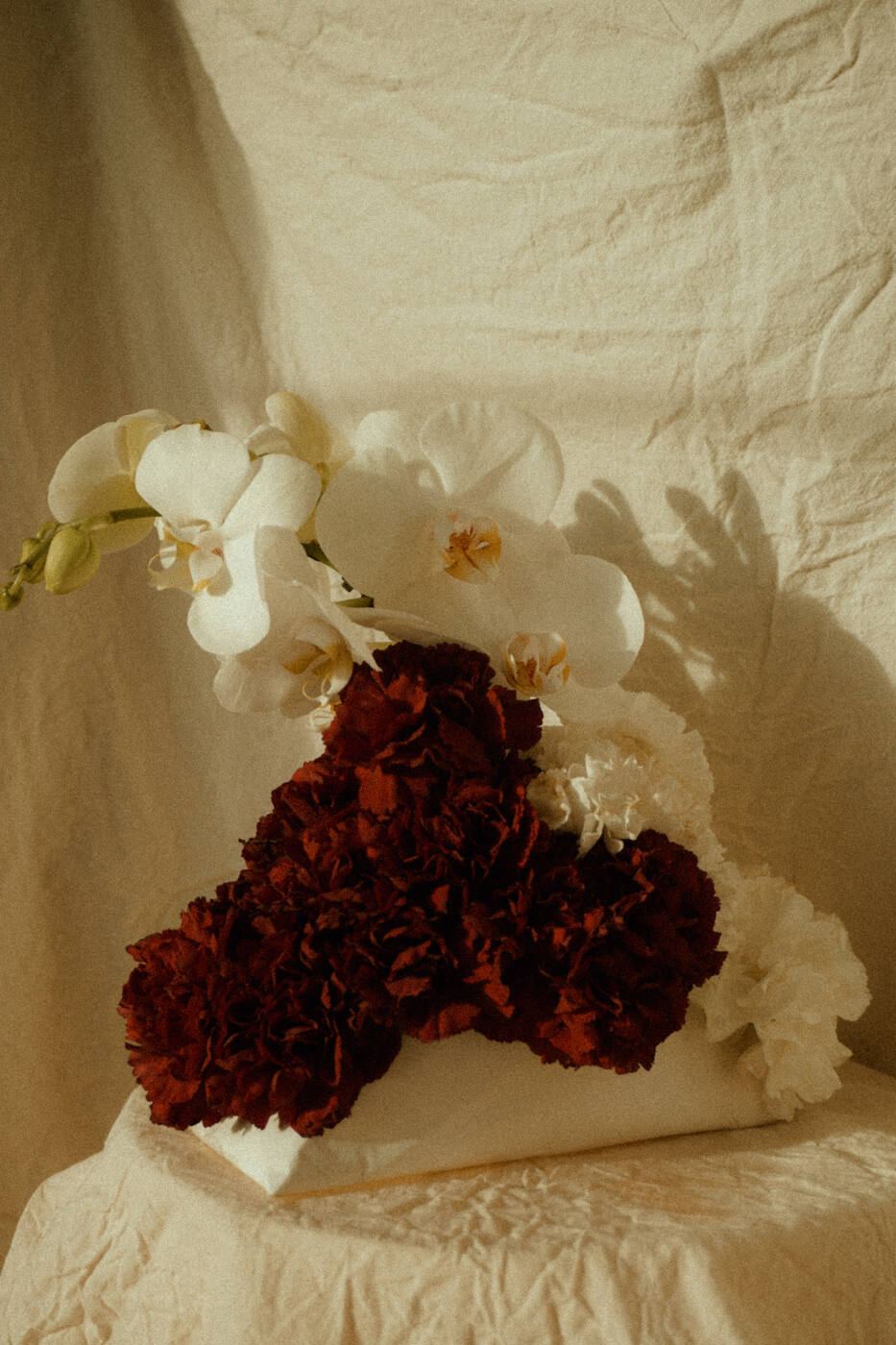 Orchids and dark red carnations