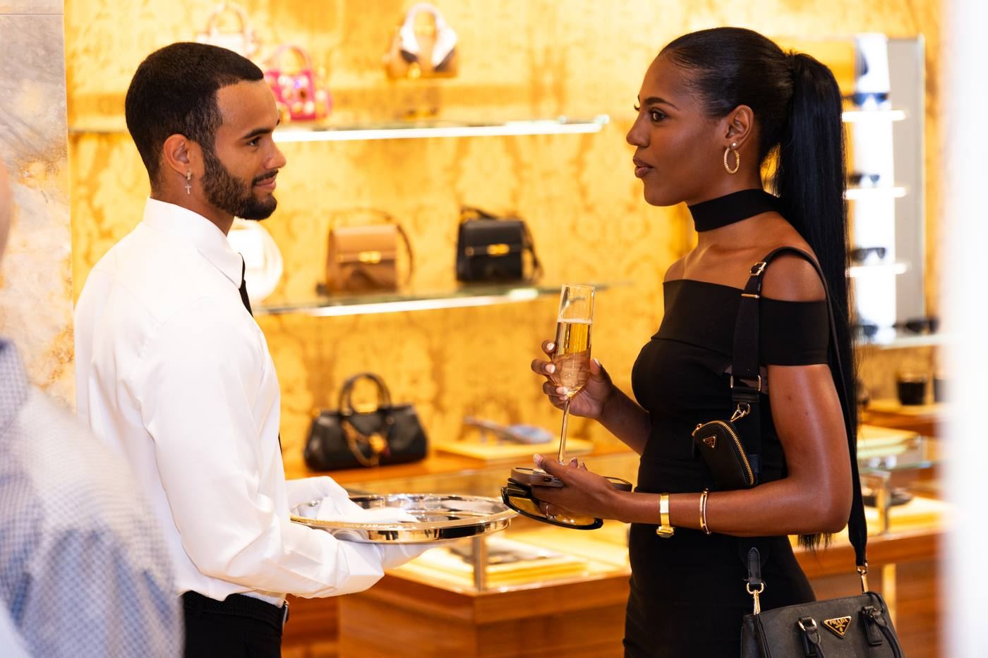 Server presenting champagne to guest at Prada