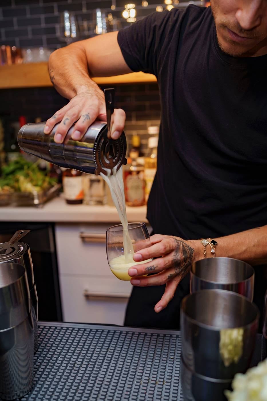 Bartender straining cocktail