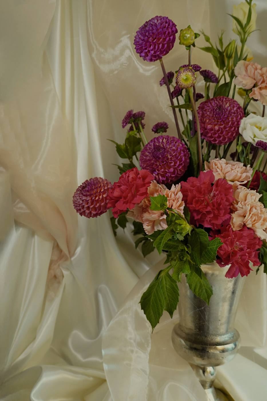 Purple dahlias and carnations in silver vase