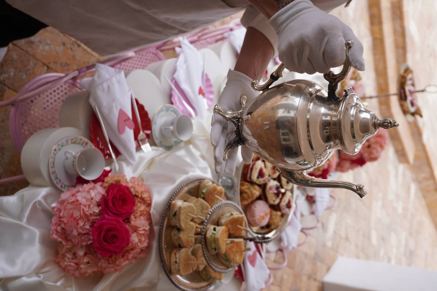 White glove silver teapot service at tea party