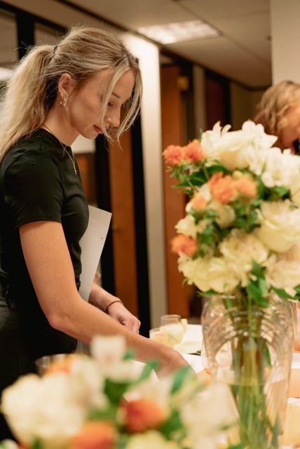 Guests gathered at a styled table with fresh florals at a Shaken cocktail master course