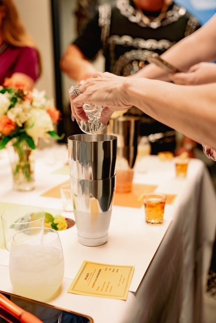 Guests building a cocktail together with professional tins at a Shaken cocktail master course