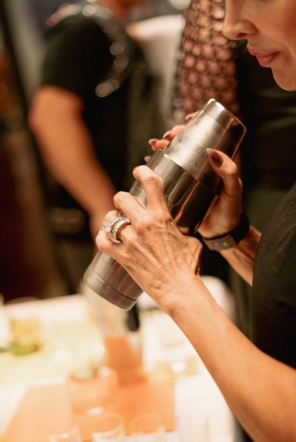 A guest shaking her own cocktail during a Shaken cocktail master course